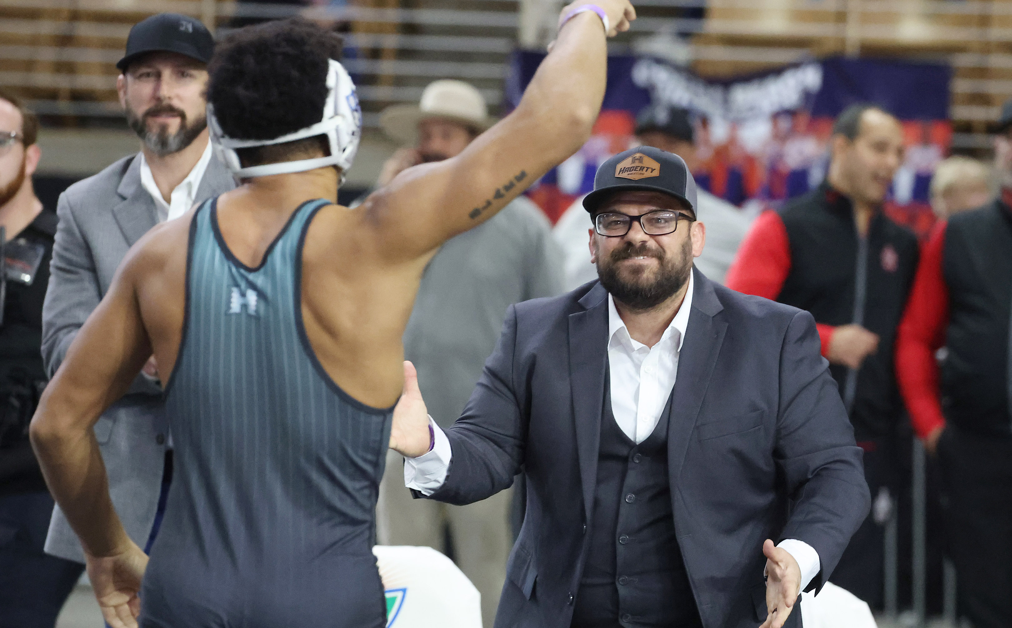 Hagerty High coach Scotty Diaz congratulates wrestler Nikolas Blake during...