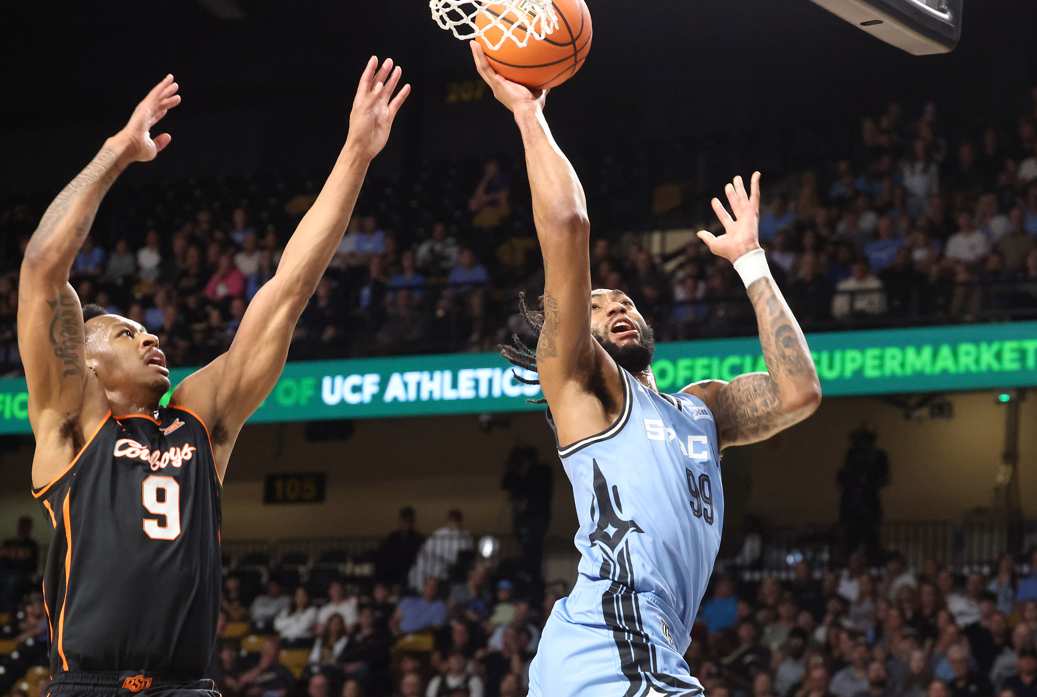 UCF forward Jordan Burks (99) scores past Oklahoma State guard...