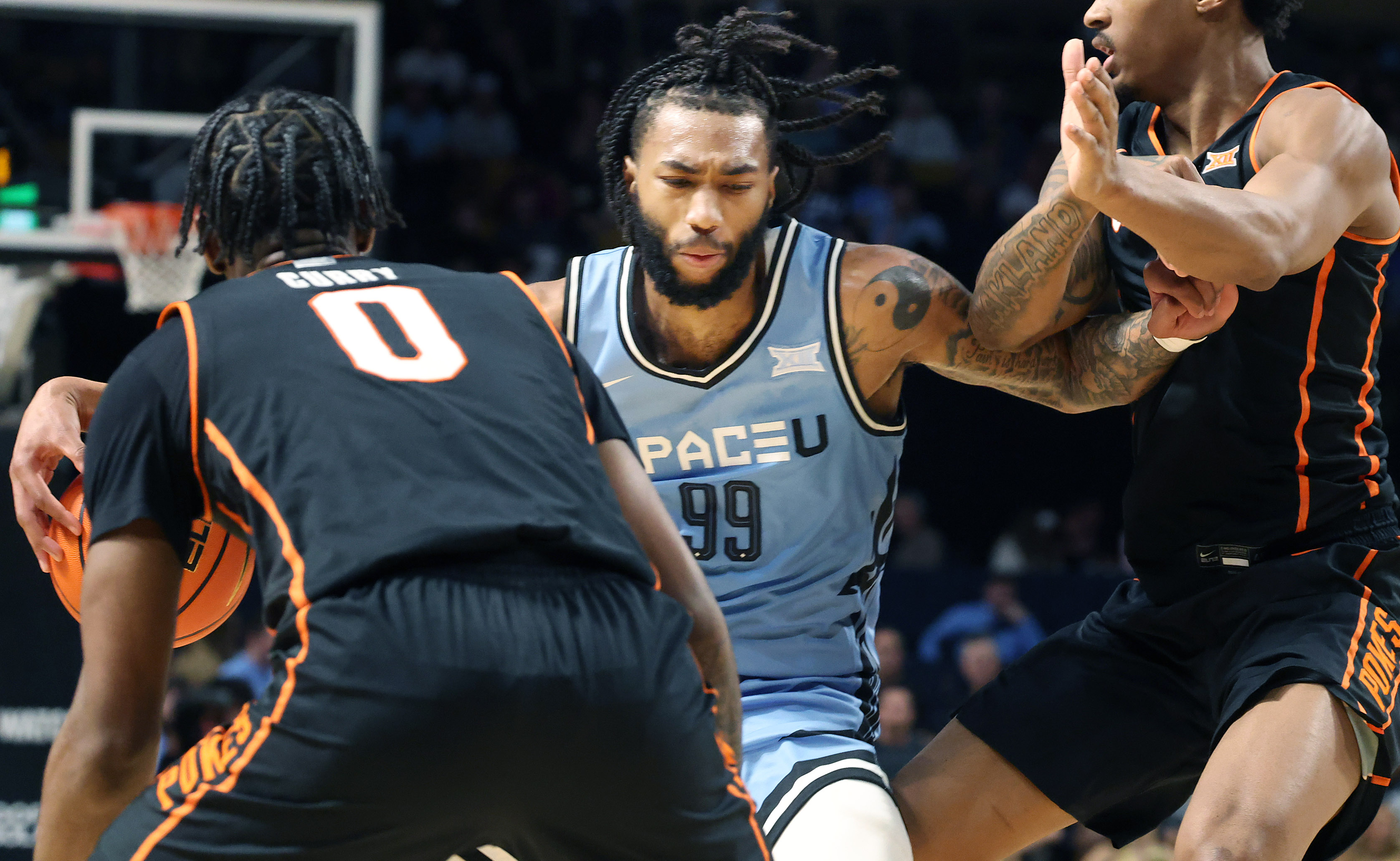 UCF forward Jordan Burks (99) shoves through defenders during the...
