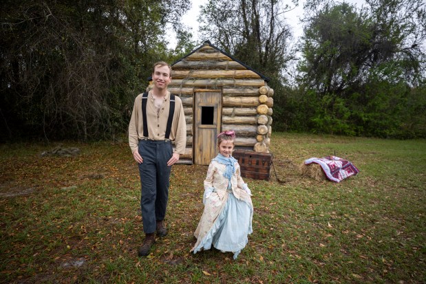 Daniel Sharkey and Emery Webb, 5, showcase their period clothing as reenactors in front of a replica 1880s cabin in the historic town of Ethel at Rock Springs Run State Reserve in Sorrento on March 12, 2026 (Patrick Connolly/Orlando Sentinel)