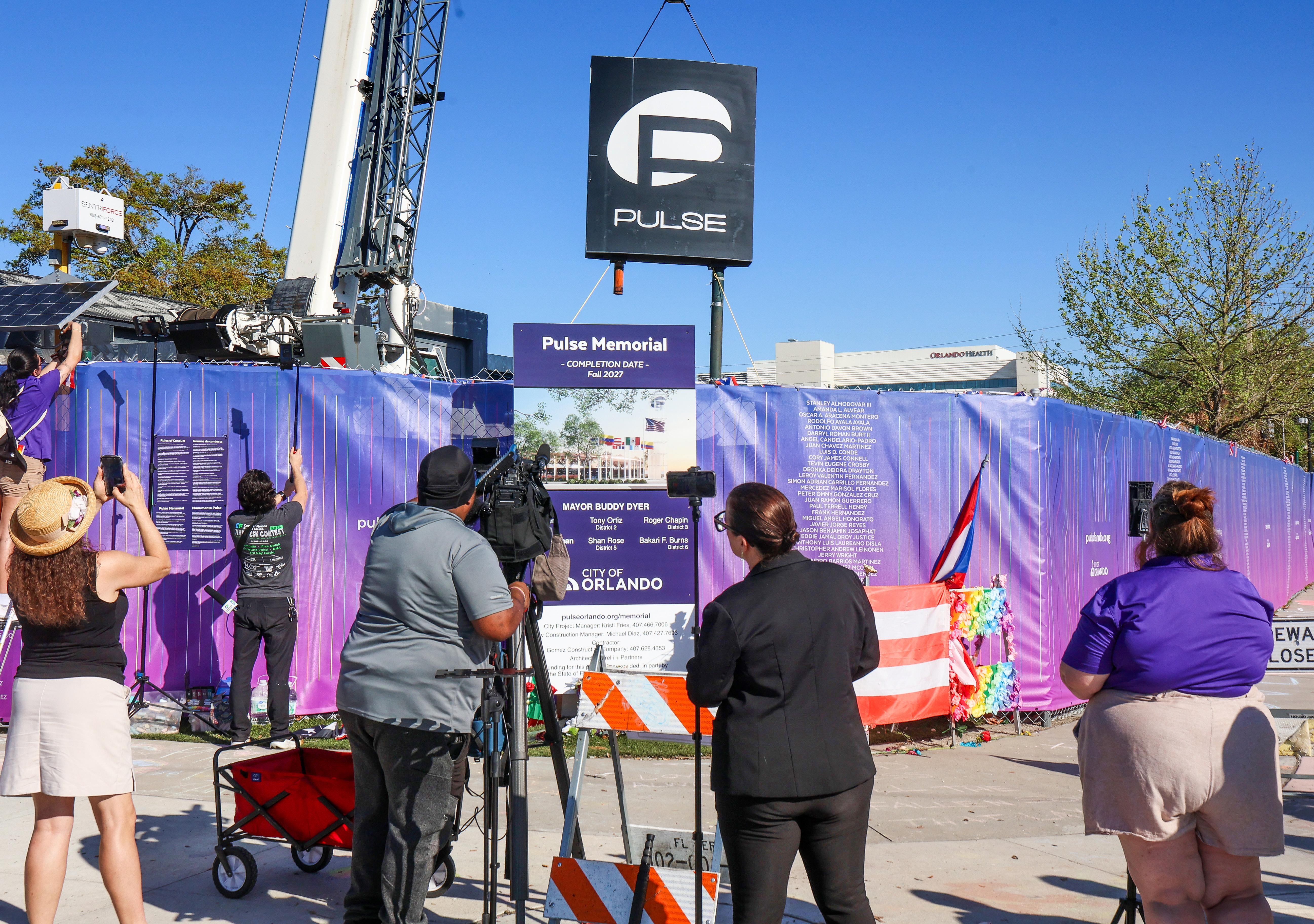 Spectators watch as the sign for the Pulse nightclub is...