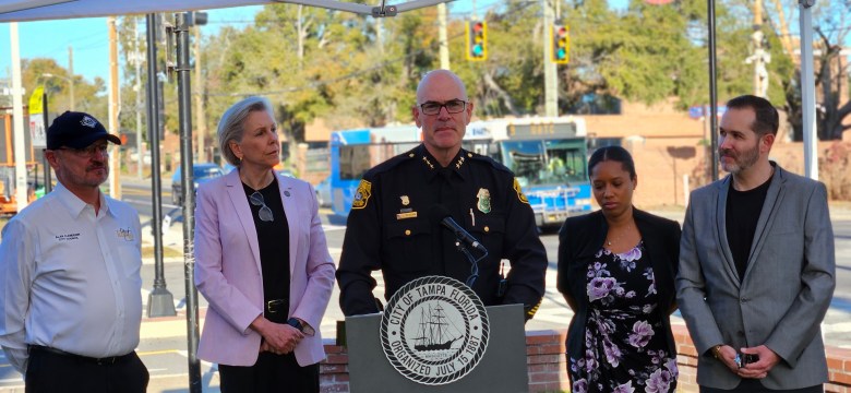 Tampa Police Chief Lee Bercaw speaks at a podium during a press conference in Tampa, Florida. Standing behind him from left to right are City Council Chair Alan Clendenin, Mayor Jane Castor, and City Councilmembers Naya Young and Guido Maniscalco.