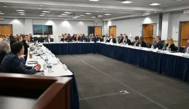 The UNF Board of Governors sit around a square conference table.