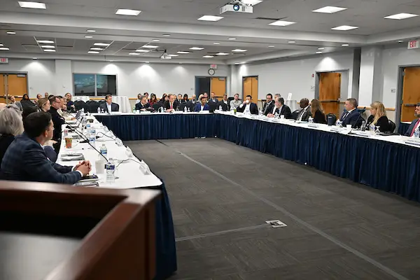 The UNF Board of Governors sit around a square conference table.