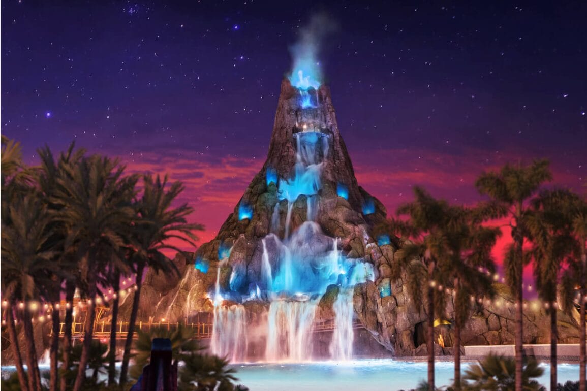 A glowing volcano waterfall at night, lit with blue lights, surrounded by palm trees under a starry sky.