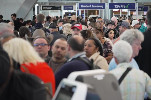 Airline passengers wait in long lines to get through the TSA security screening at George Bush Intercontinental Airport in Houston on Wednesday, March 18, 2026. (AP Photo/Lekan Oyekanmi)