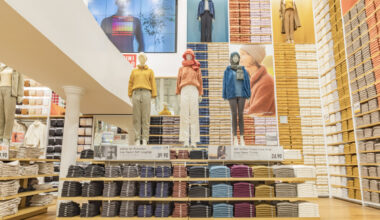 A photo of mannequins wearing winter clothing inside a Uniqlo clothing store.