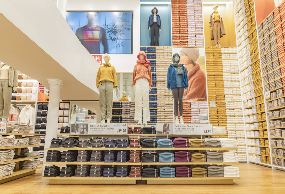 A photo of mannequins wearing winter clothing inside a Uniqlo clothing store.