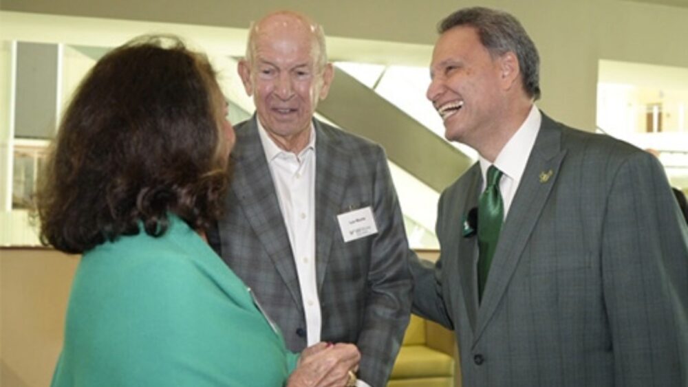 USF President Moez Limayem speaks with Pam and Les Muma during an event in his first week in office.