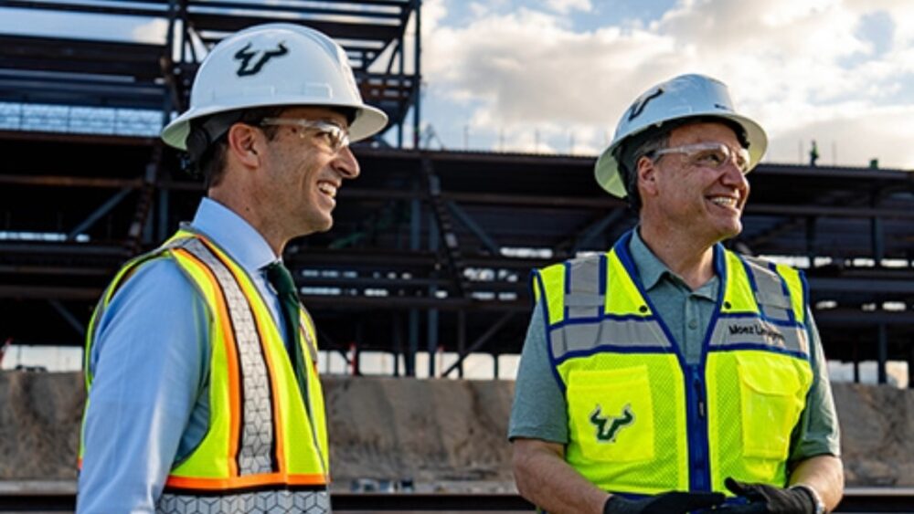 USF President Moez Limayem and Athletics CEO Rob Higgins tour the on-campus stadium construction site wearing hard hats and safety vests.