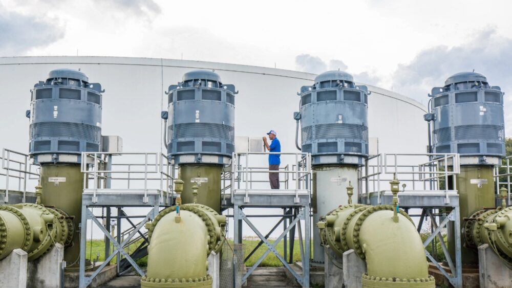 Raw water pumps at Tampa Bay Water’s Regional Surface Water Treatment Plant, with operator inspecting equipment.