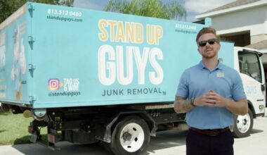 Casey Walsh stands in front of a Stand Up Guys Junk Removal truck in Tampa.