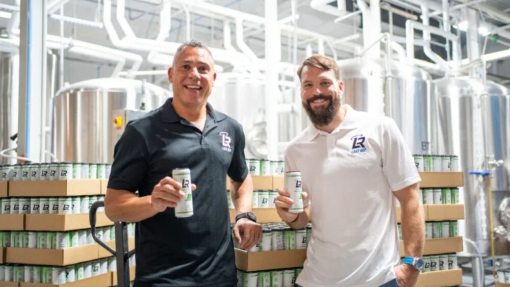 Jason Ashton (left) and Stephen Samson hold cans of Last Rep THC recovery drink at a production facility.