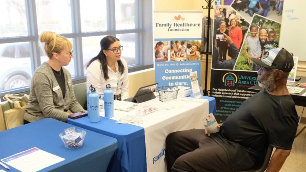 Community partners from Family Healthcare Foundation speak with a resident at a PD13 Street Legal outreach clinic in Tampa’s University Area.