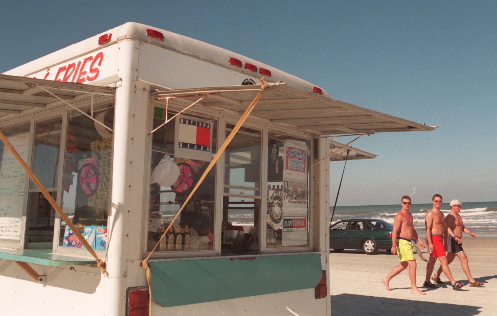 Spring breakers from Penn State walk by one of the...