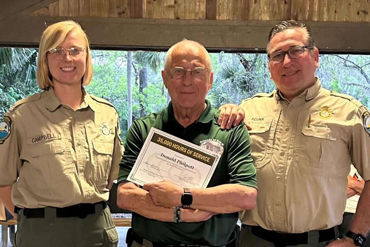 From left to right: Wekiwa Springs State Park service specialist Emily Campbell (left) and park manager Rene Acuna (right) pose with Don Philpott.