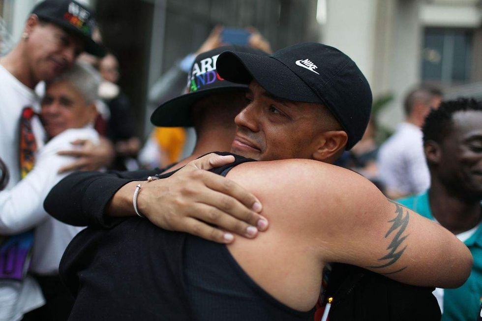 brandon wolf wearing a hat and hugging a person with a tattoo