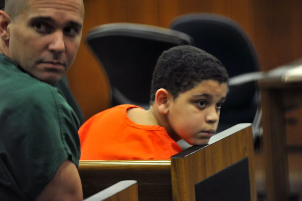 Cristian Fernandez, 12, rests his chin on the courtroom bench as the other prisoners arrive for hearings. He was arraigned in first court appearance in the death of his 2 year-old half brother in front of Judge Del Wallace on June 4, 2011, in Jacksonville.