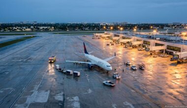 Delta jet parked on a wet Fort Lauderdale airport tarmac at dusk after an emergency diversion.