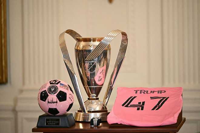 The 2025 MLS Soccer Cup trophy, a ball, a watch and a jersey are seen before US President Donald Trump hosts an event for Inter Miami CF, winners of the 2025 Major League Soccer Cup, in the East Room of the White House in Washington, DC, on March 5, 2026. (Photo by ANDREW CABALLERO-REYNOLDS / AFP via Getty Images)