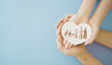 Hands holding diversity family in heart shape, happy carer and volunteer, disable nursing home, rehabilitation and health insurance concept