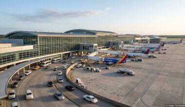 Exterior of Jacksonville International Airport terminal with planes and traffic on a clear morning.