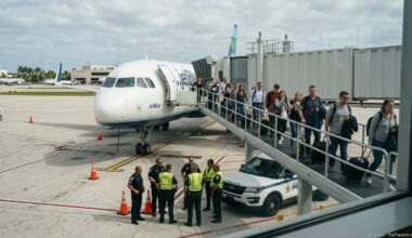 Passengers and police near a parked JetBlue jet during an evacuation at Fort Lauderdale airport.