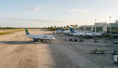 JetBlue aircraft lined up at Fort Lauderdale airport gates on a sunny afternoon.