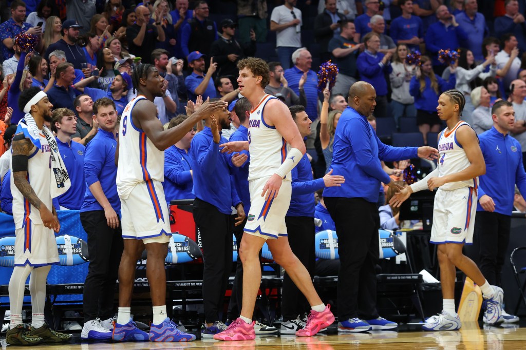 Two basketball players from the Florida Gators high five during a game.