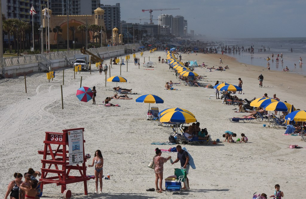 People enjoying warm weather on Daytona Beach during Spring Break.