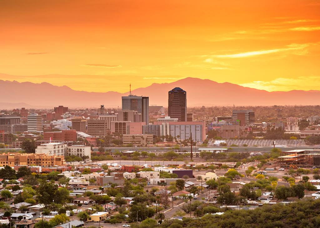 A downtown city skyline with mountains at twilight in Tucson, Arizona, USA.