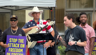 Mike Ludwick, who made a complaint about prayer at school board meetings, seen here holding a guitar and standing in front of the Duval Schools headquarters on Oct. 7, 2025.