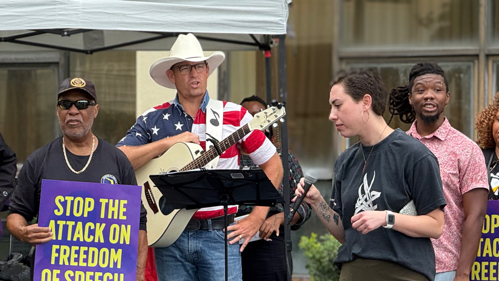 Mike Ludwick, who made a complaint about prayer at school board meetings, seen here holding a guitar and standing in front of the Duval Schools headquarters on Oct. 7, 2025.
