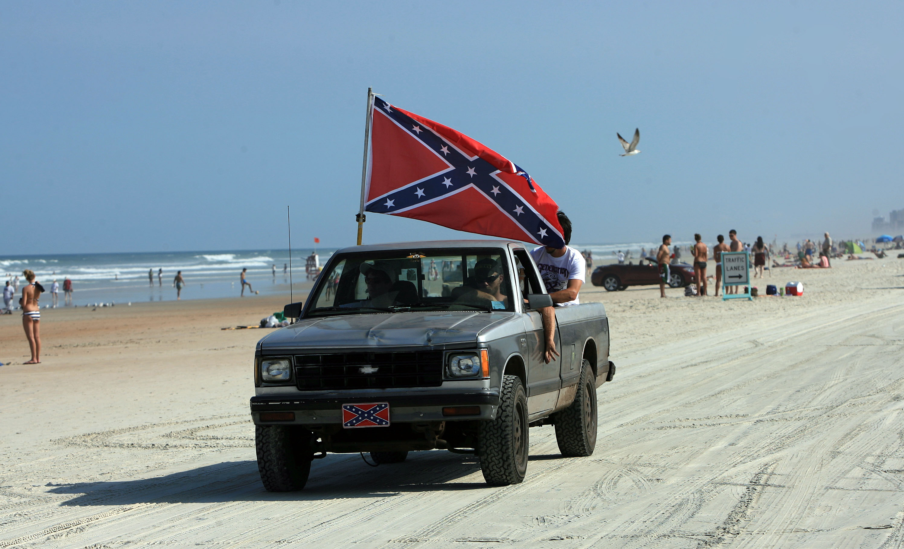 A truck flying the confederate flag drives down Daytona Beach...