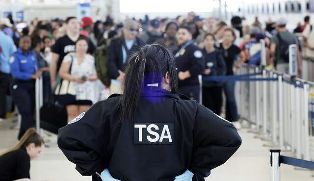 A TSA agent stands guard at a security checkpoint at Fort Lauderdale-Hollywood International Airport on Monday, March 23, 2026.