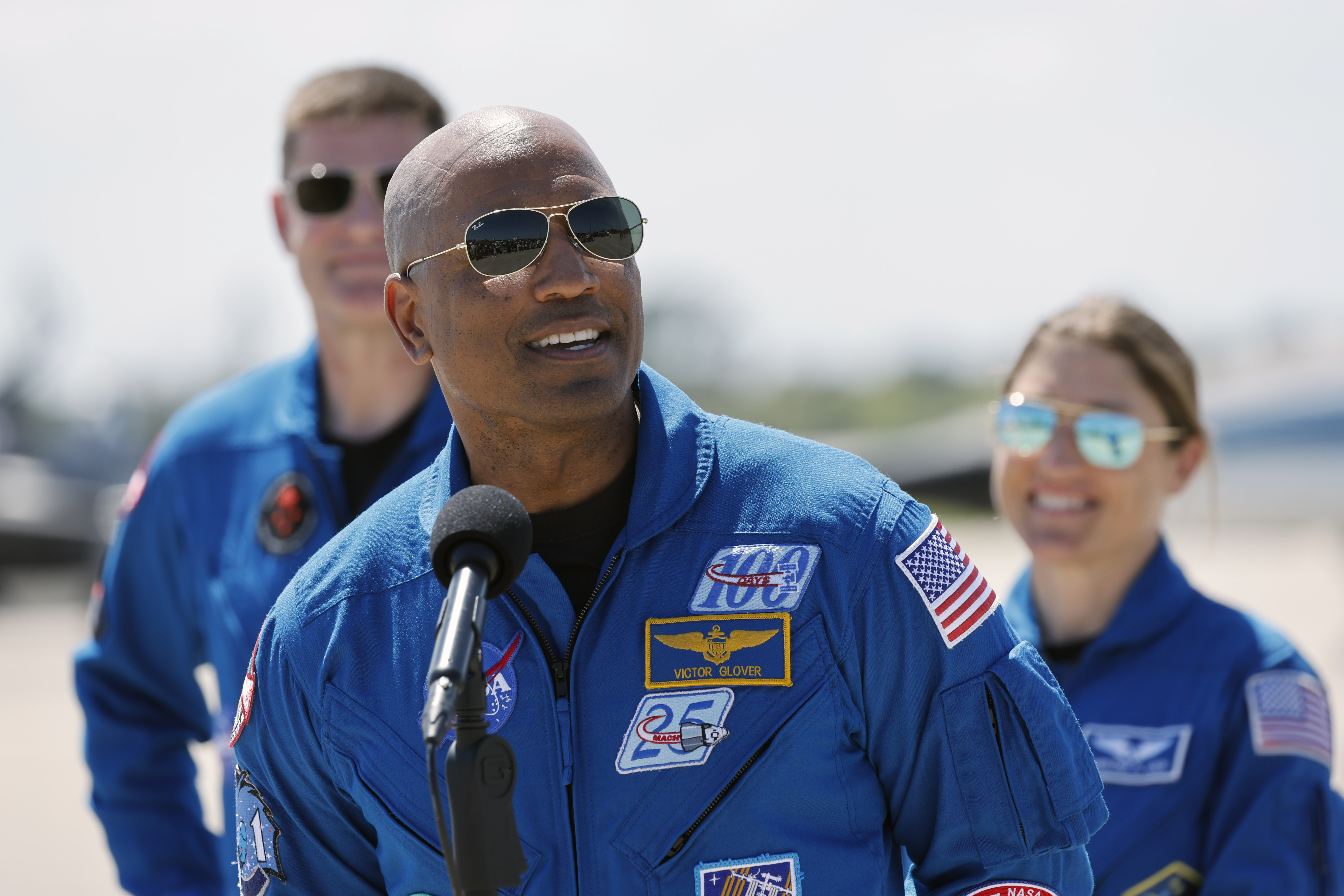 Artemis II pilot Victor Glover speaks as mission specialists Jeremy...