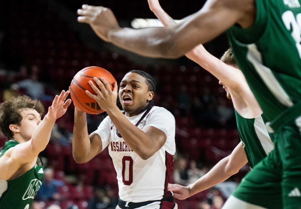 UMass guard Danny Carbuccia is surrounded by Ohio defenders during a basketball game.