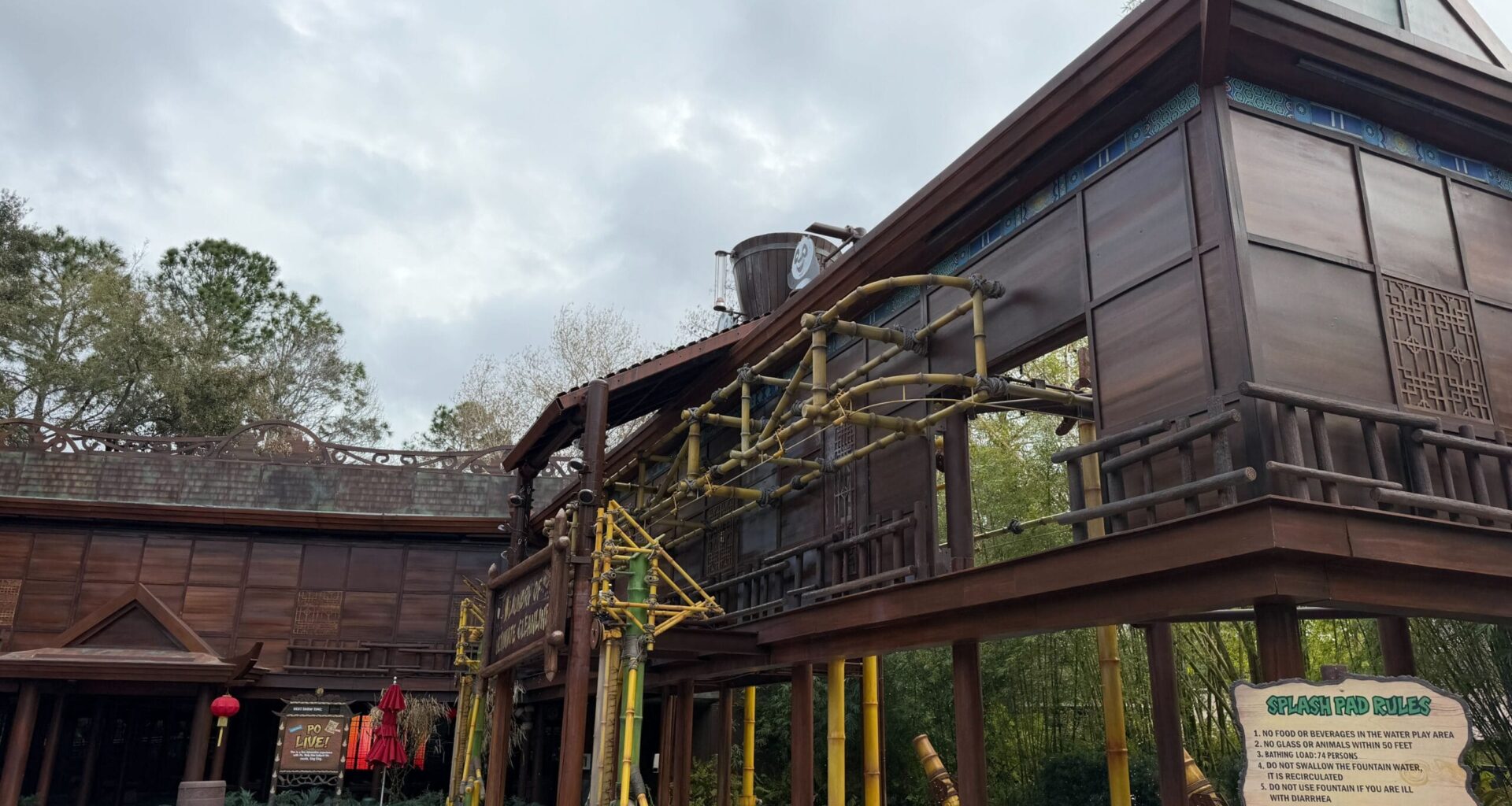 The bucket is located atop an exterior structure near Po Live!, part of a laundry-themed area. The bucket periodically tips forward, sending water across the ground (and any guests in its way). See the effect in action below.