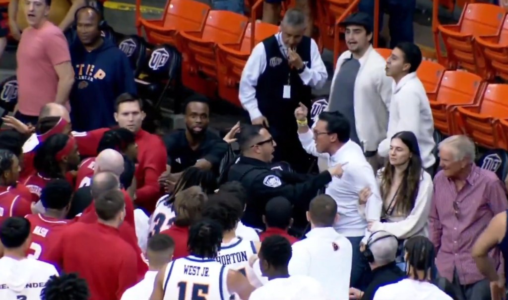 An angry UTEP fan is confronted by a security guard amid an altercation with Jacksonville State players after a men's college basketball game on March 7, 2026.