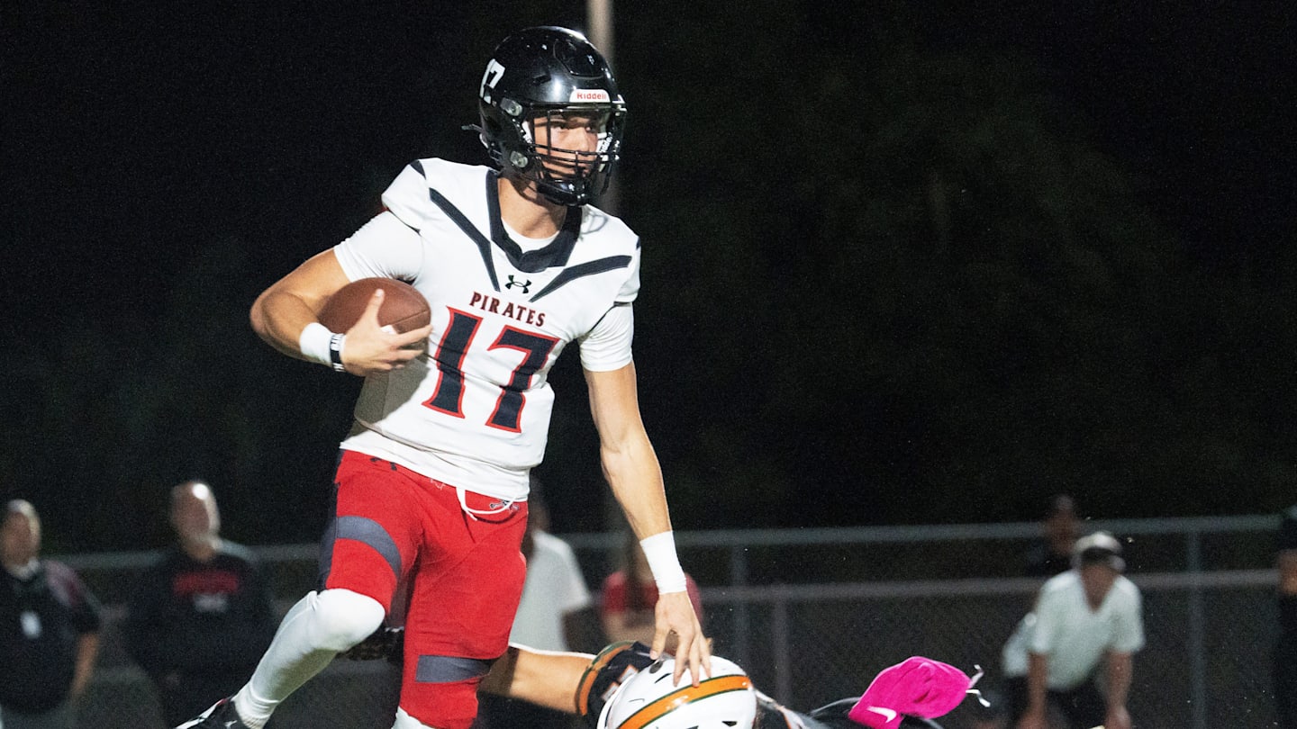 Logan Flaherty, the quarterback of Port Charlotte eludes a Dunbar defender during a game at Dunbar on Friday, Oct. 10, 2025. Port Charlotte won.