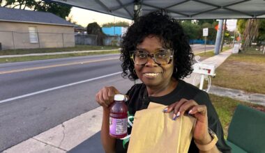 Diane Wingfield hands out snacks to school kids in front of Agape Church of God in Christ. (Spectrum News)