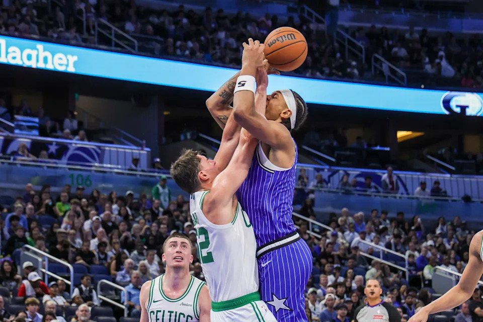 Nov 9, 2025; Orlando, Florida, USA; Orlando Magic forward Paolo Banchero (5) is fouled by Boston Celtics center Luka Garza (52) during the second half at Kia Center. Mandatory Credit: Mike Watters-Imagn Images