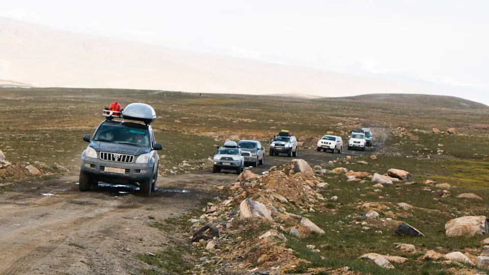 Convoy of Off-Road Vehicles on Remote Dirt Road