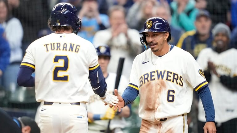 Milwaukee Brewers' David Hamilton (6) high-fives Brice Turang (2) following...