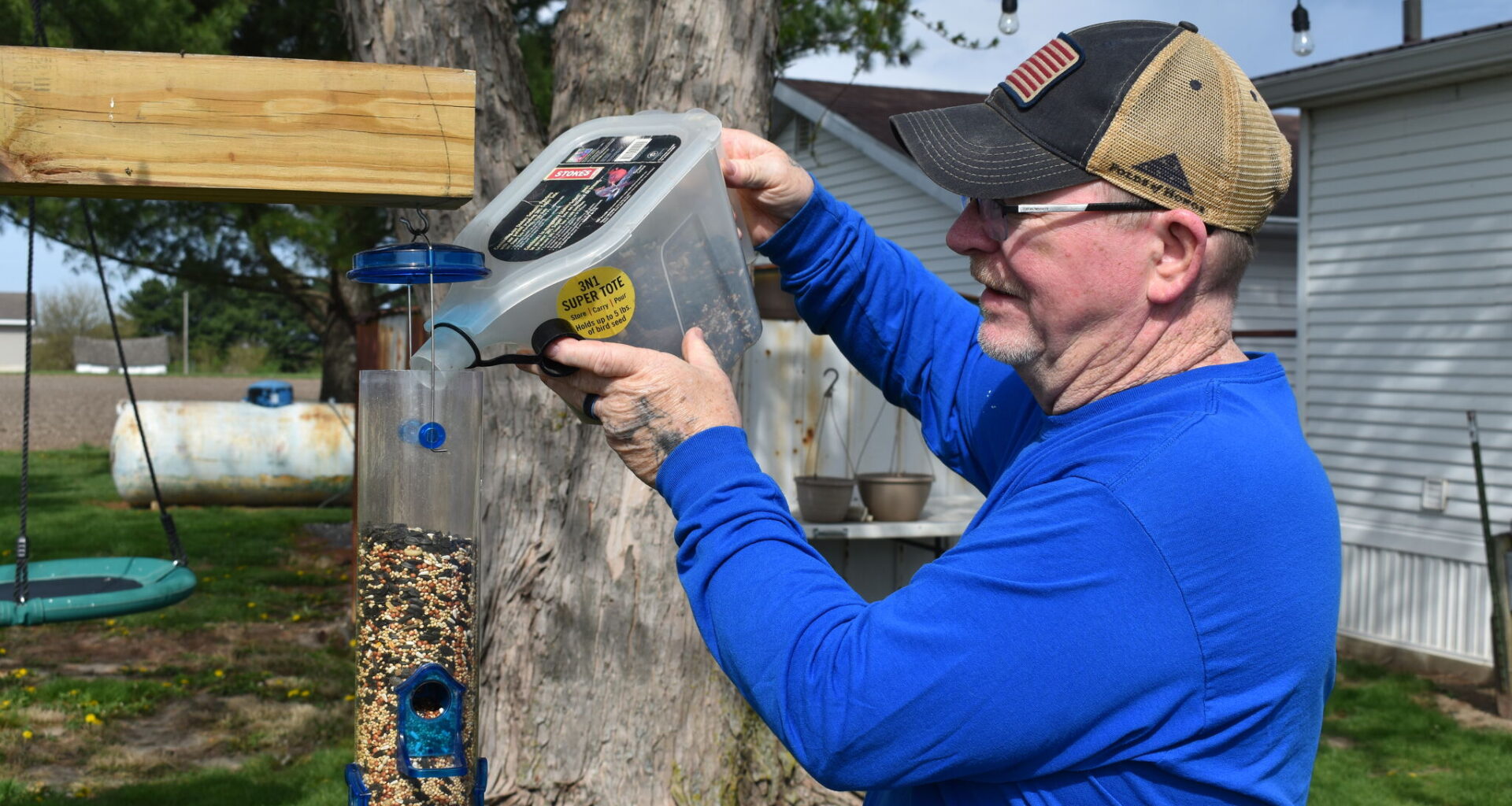 Aaron Wills of Jacksonville fills the bird feeders in his yard that help him attract various birds, including a rare leucistic robin. 