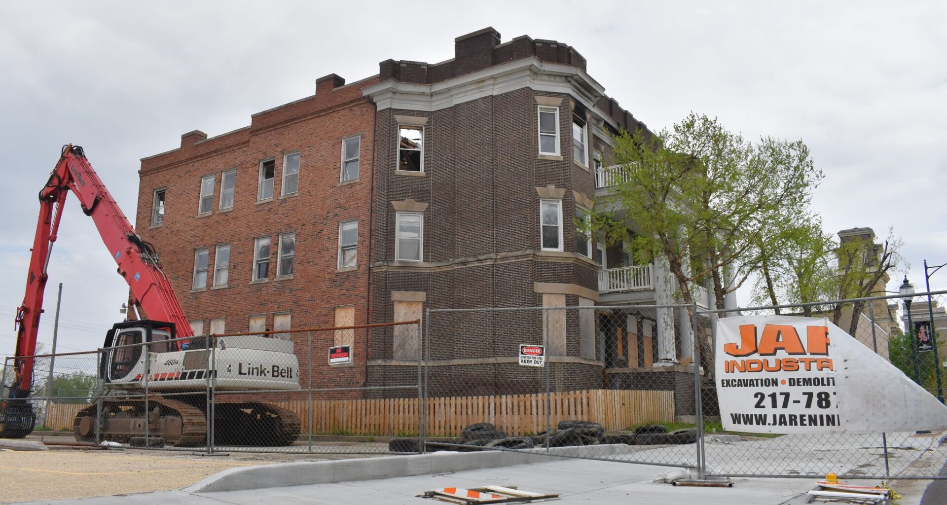 A crane sits outside an abandoned apartment building. The building caught fire in January and is awaiting demolition.