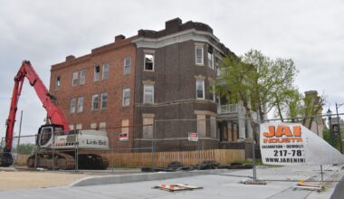 A crane sits outside an abandoned apartment building. The building caught fire in January and is awaiting demolition.