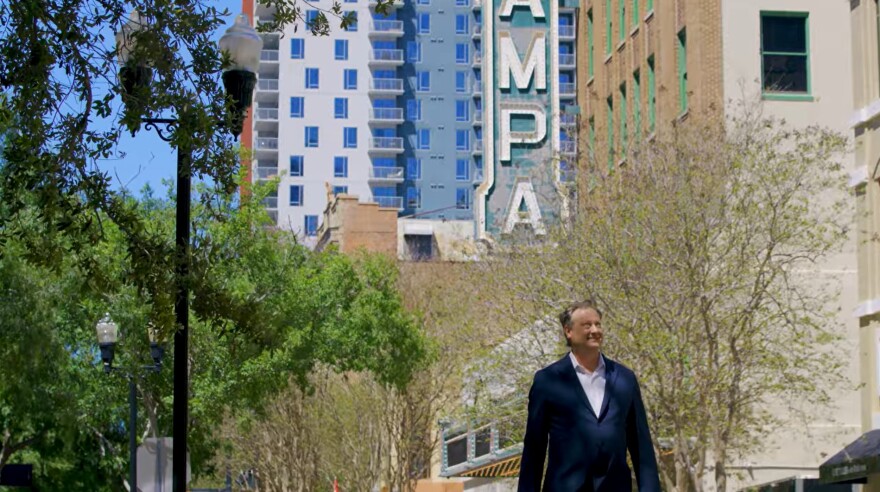 Man walks below Tampa sign 