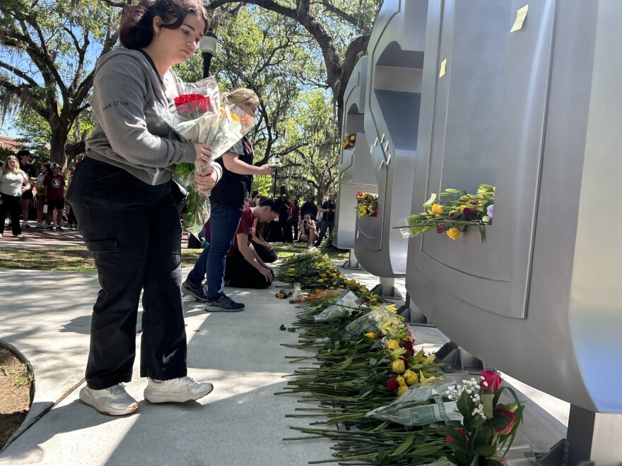 FSU sophomore Gabriella Nogueira leaving flowers at the FSU memorial.