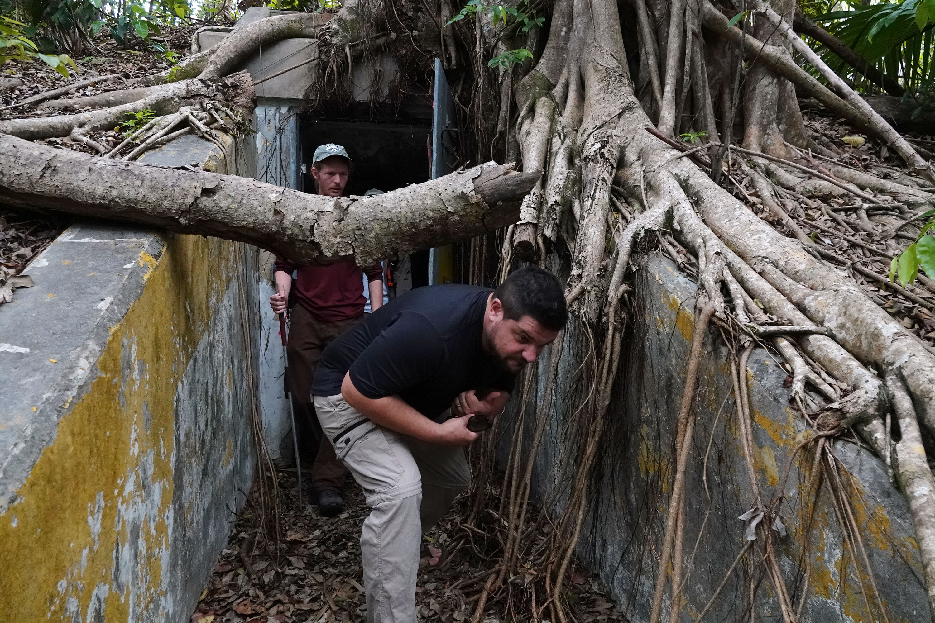 Isaac Lord, left, and Mike Cove inspect an abandoned Cold War-era Nike missile bunker on Wednesday at the Crocodile Lake National Wildlife Refuge in Key Largo. The bunkers attract invasive pythons and the small mammals they prey upon. (Joe Cavaretta/South Florida Sun Sentinel)